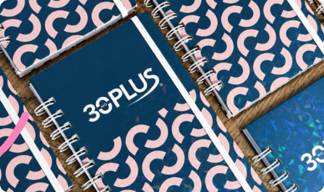 Agendas corporativas 30PLUS sobre mesa de madera